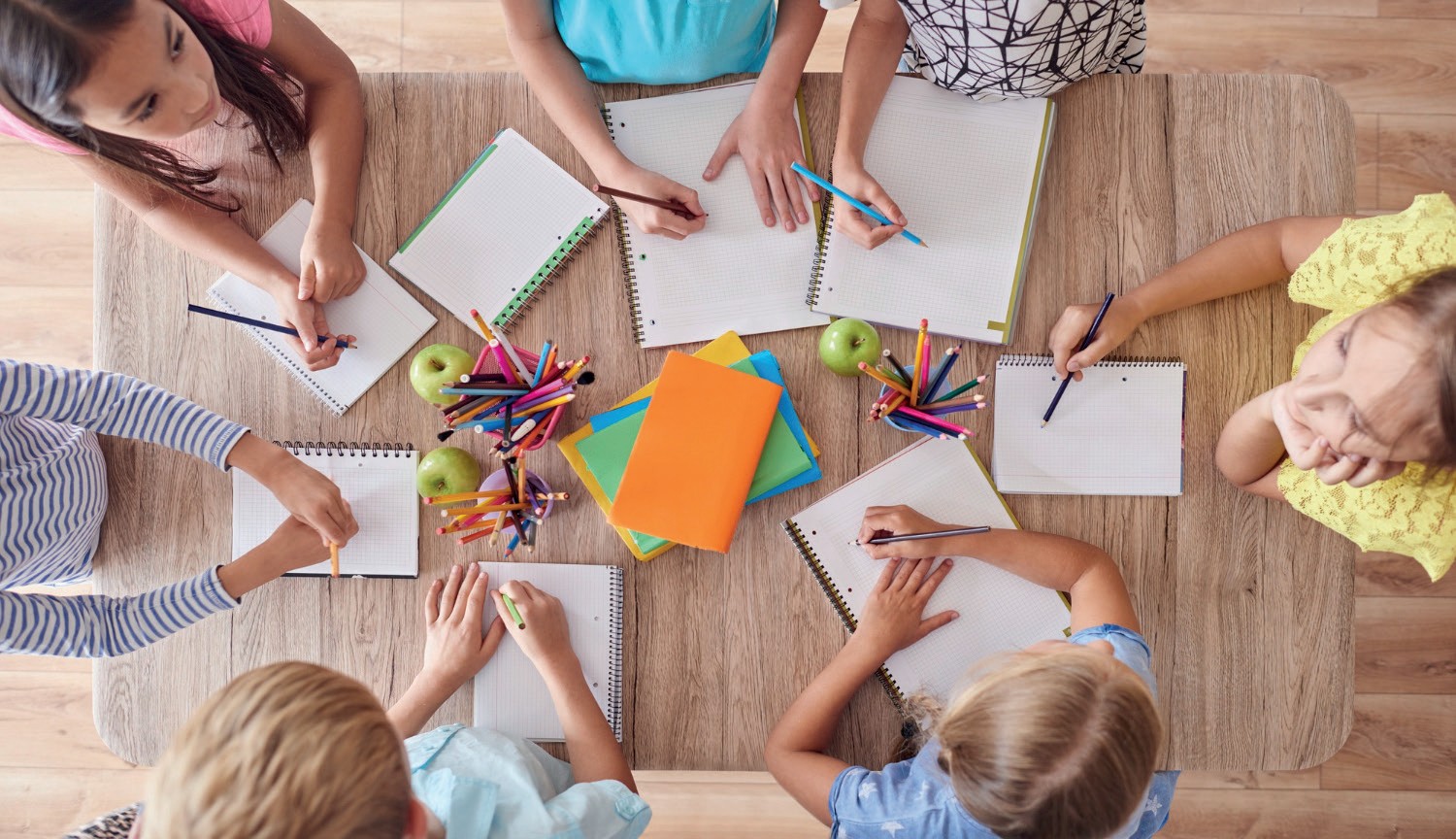 Bambini che studiano insieme attorno a un tavolo
